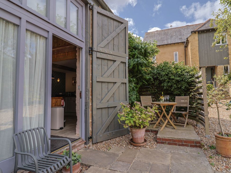 An outdoor seating area with a table and chairs at The Stone Barn in Bridport