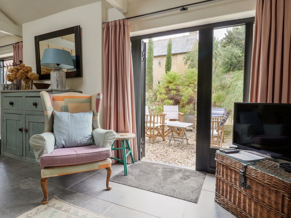 A living room with a chair and table at The Dairy in Bridport