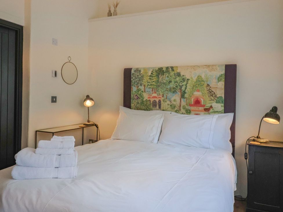 A bedroom with a bed and towels at The Dairy in Bridport