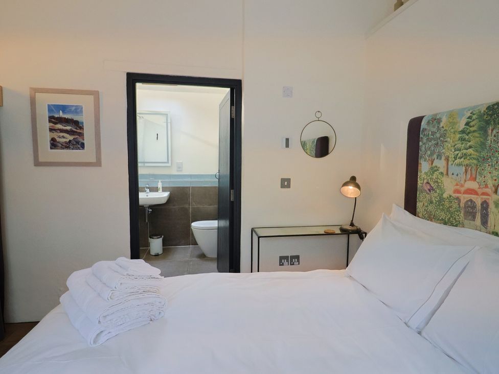 A bedroom with a bed and an en suite bathroom at The Dairy in Bridport