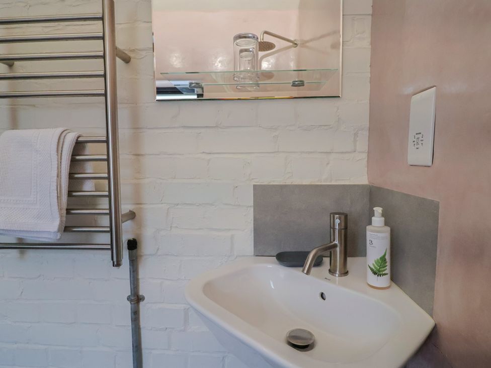 A bathroom with a sink and towel rack at The Dairy Bridport