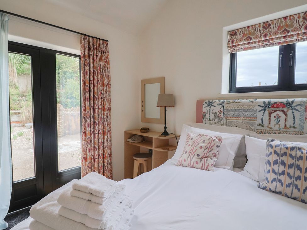 A bedroom with a bed and a nightstand at The Dairy in Bridport