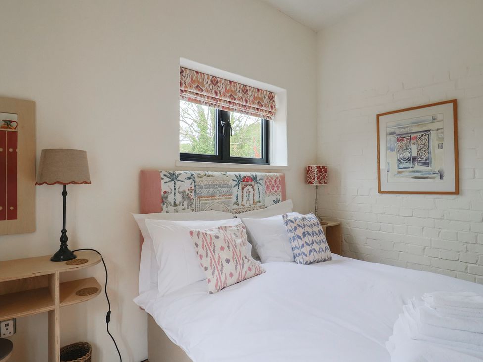 A bedroom with a bed and lamp at The Dairy in Bridport
