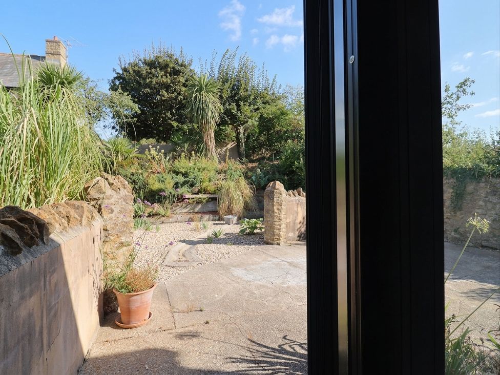 A garden with plants and paving stones at The Dairy in Bridport