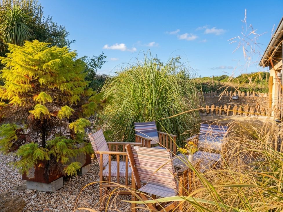 An outdoor seating area with plants and chairs at The Dairy in Bridport
