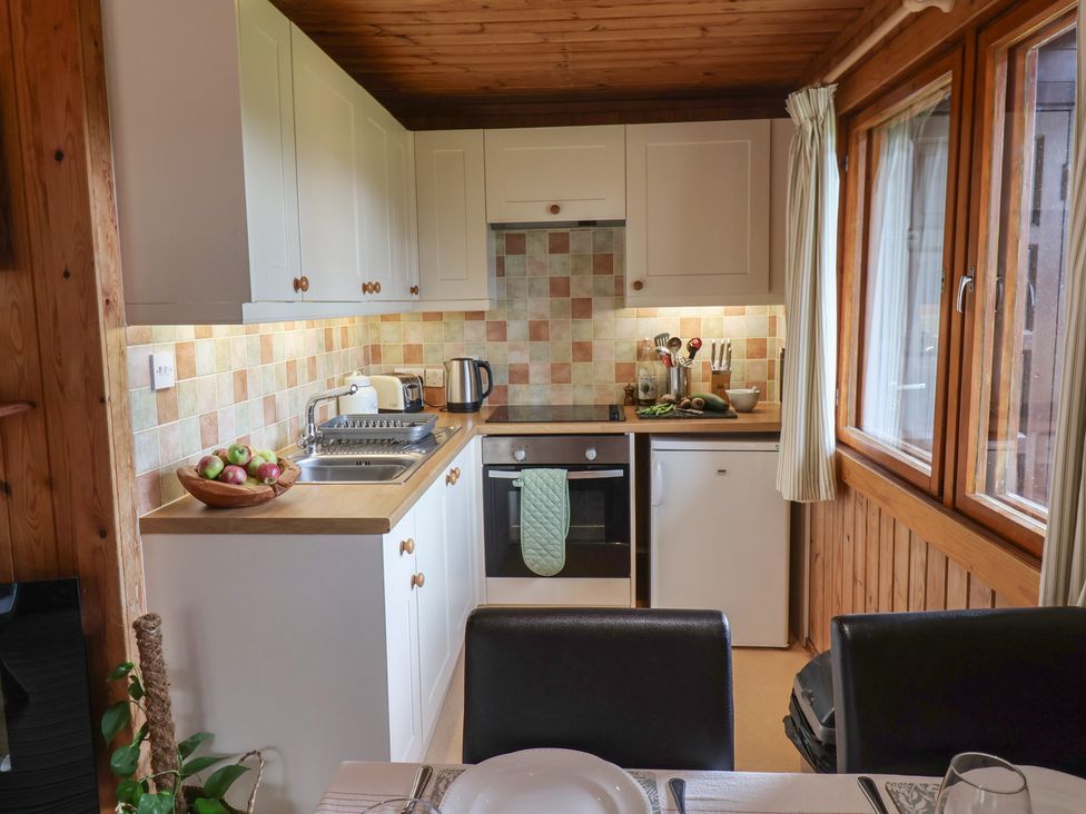 A kitchen with appliances and dining setup at 10 Pinewood Retreat in Pinewood