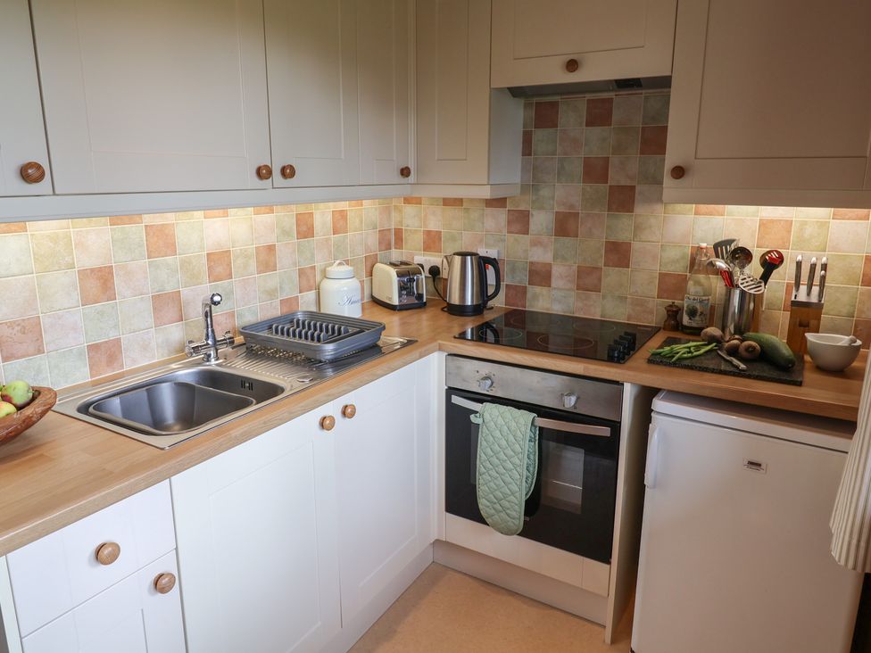 A kitchen with a sink and cooking appliances at 10 Pinewood Retreat in Pinewood