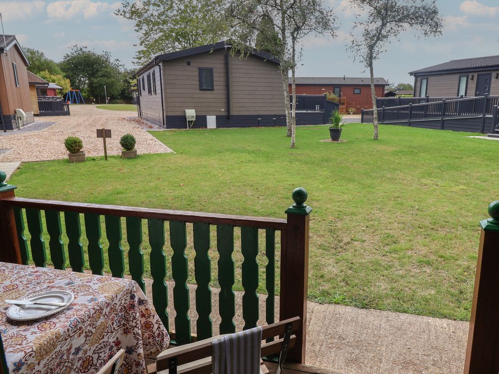 A garden with grass and cabins at 10 Pinewood Retreat in Pinewood