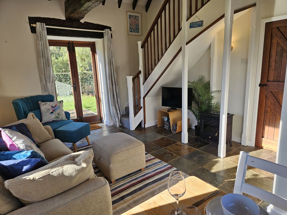 A living room with a sofa and TV at The Cider House in Dalwood