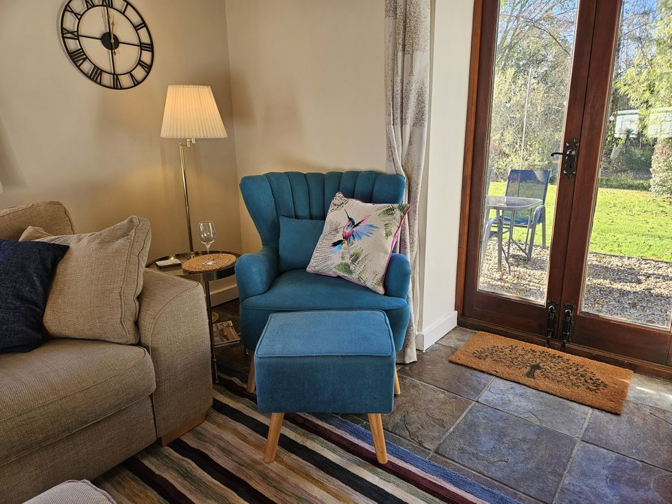 A living room with furniture including a chair and couch at The Cider House in Dalwood