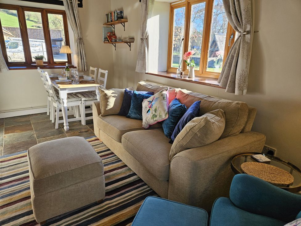 A living room with a sofa and dining table at The Cider House in Dalwood
