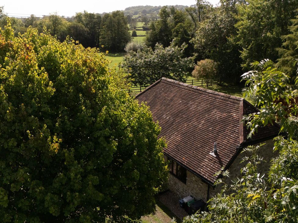 A house with a roof and trees in the garden at The Cider House in Dalwood
