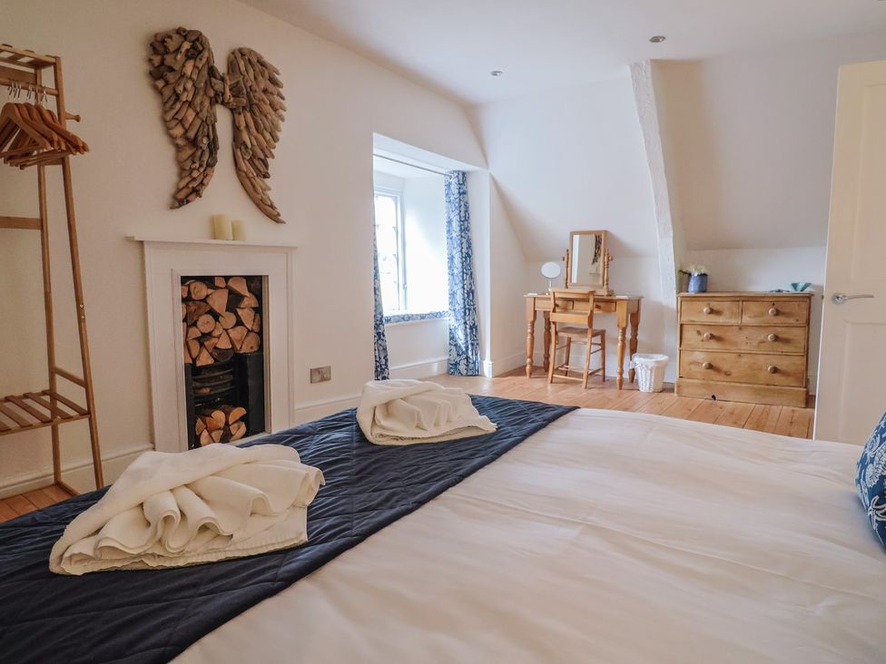 A bedroom with a bed and dresser at The Little Rose in Lyme Regis
