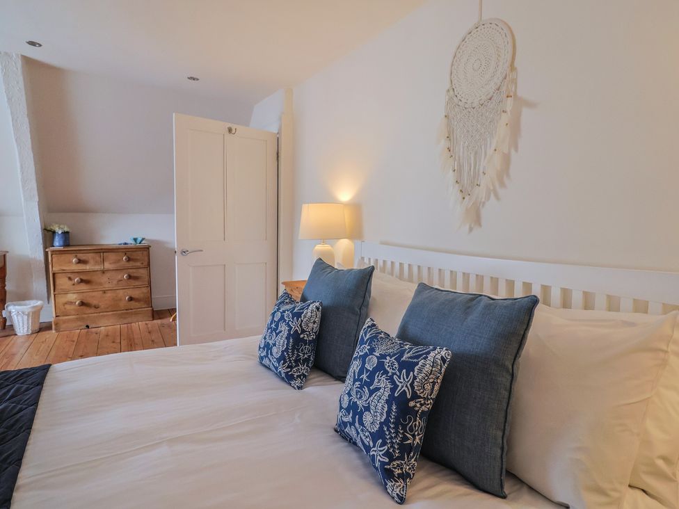 A bedroom with a bed and dresser at The Little Rose in Lyme Regis