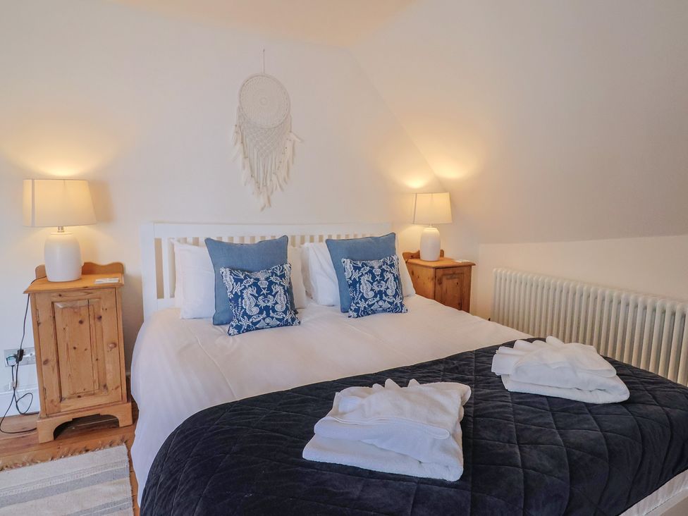 A bedroom with a bed and pillows at The Little Rose in Lyme Regis
