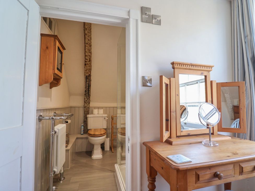 A bathroom with a toilet, vanity table, and mirrors at The Little Rose in Lyme Regis
