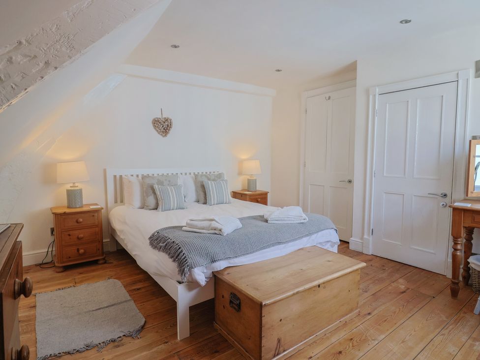 A bedroom with a bed, bedside tables, and a chest at The Little Rose in Lyme Regis