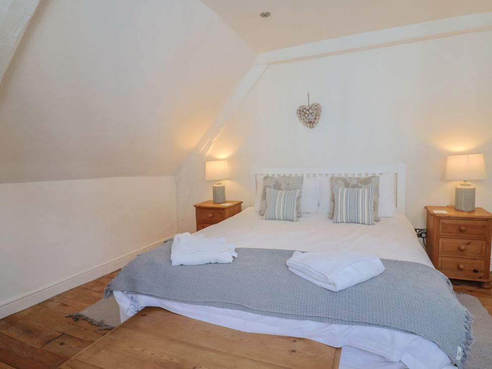 A bedroom with a bed and nightstands at The Little Rose in Lyme Regis