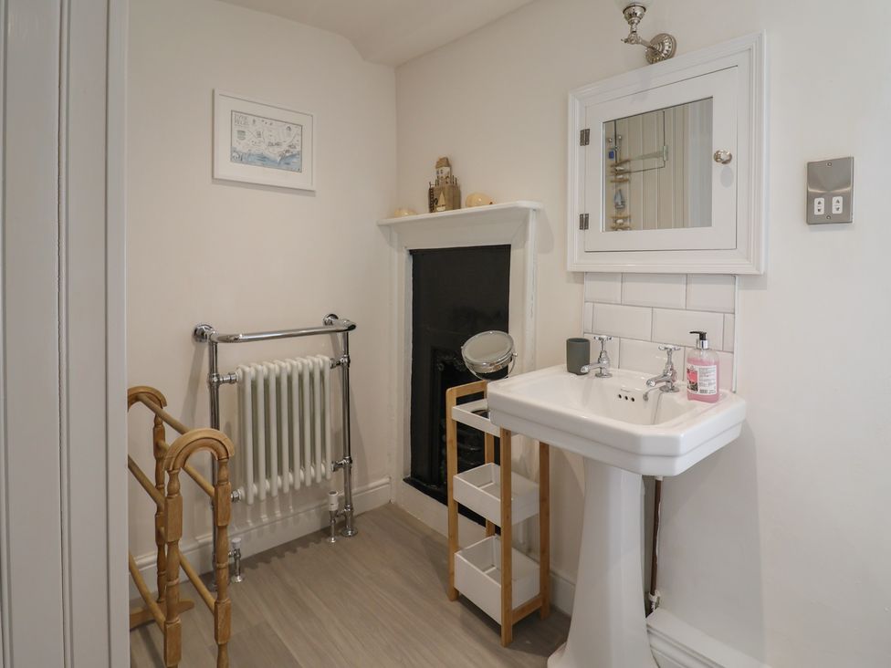 A bathroom with a wash basin and a radiator at The Little Rose in Lyme Regis