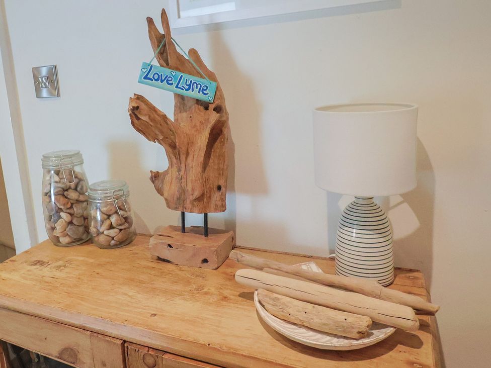A living room with a wooden table and decorative items at The Little Rose in Lyme Regis