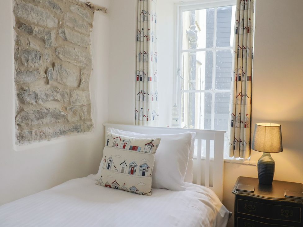 A bedroom with a bed and window at The Little Rose in Lyme Regis