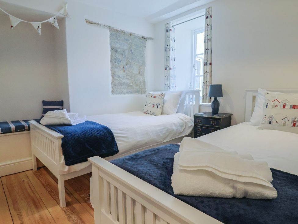 A bedroom with two beds and a window at The Little Rose in Lyme Regis