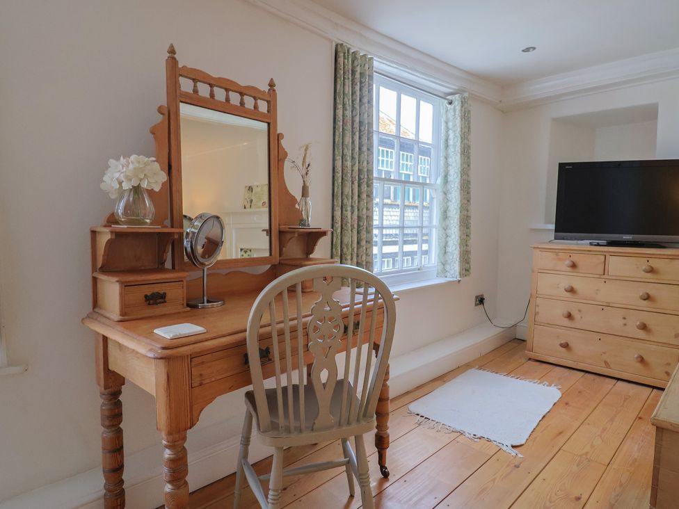 A bedroom with a desk and television at The Little Rose in Lyme Regis