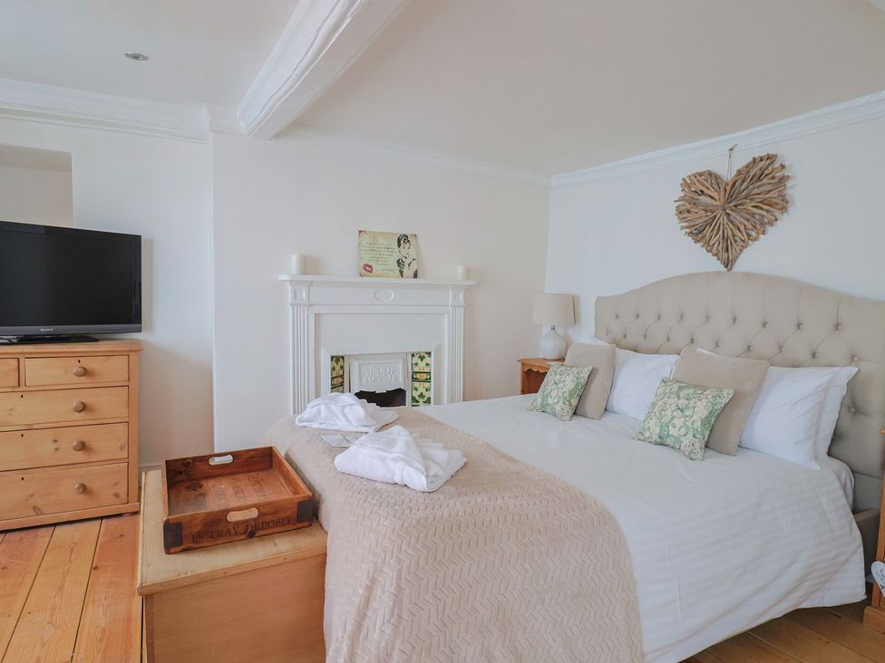 A bedroom with a bed and television at The Little Rose in Lyme Regis