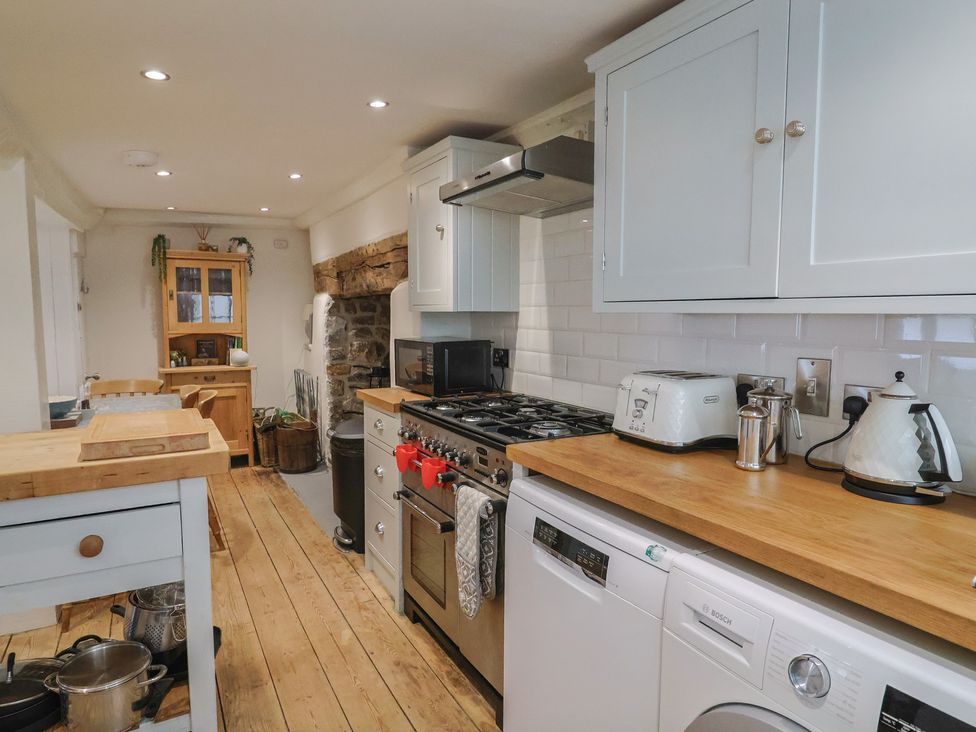 A kitchen with appliances and wooden surfaces at The Little Rose in Lyme Regis
