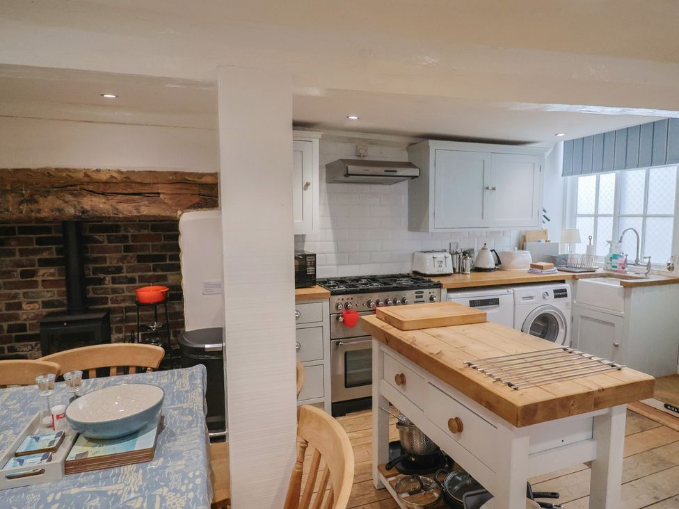 A kitchen with appliances and a dining table at The Little Rose in Lyme Regis