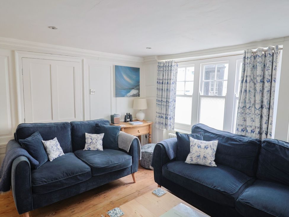 A living room with two sofas and a table at The Little Rose in Lyme Regis
