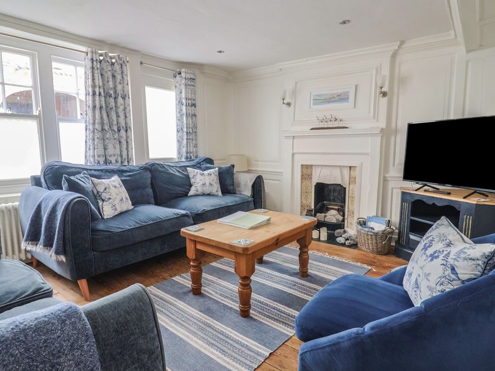 A living room with a sofa and television at The Little Rose in Lyme Regis
