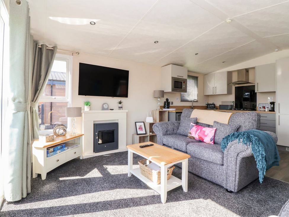 A living room with a sofa, coffee table, and television at Away Daze in Carnaby near Bridlington