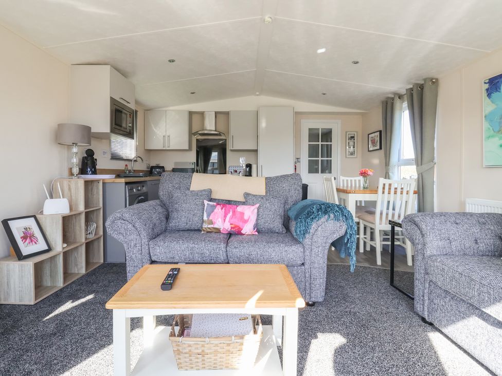 A living room with a sofa and dining area at Away Daze in Carnaby near Bridlington