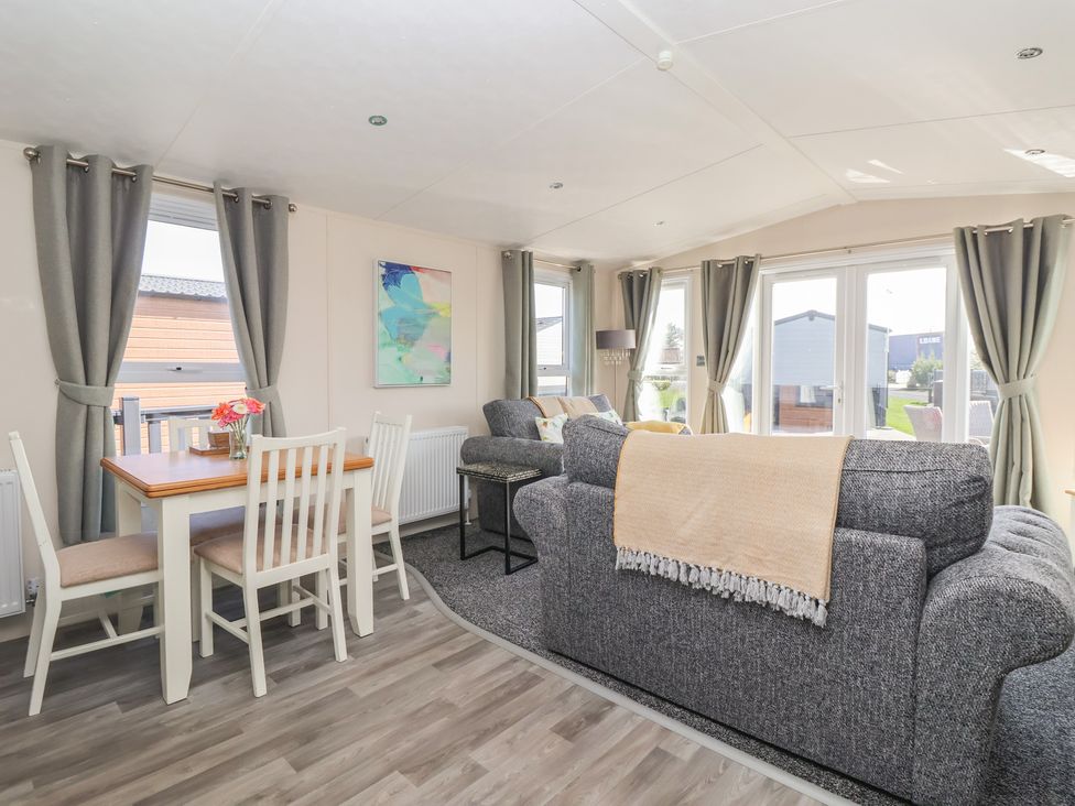 A living room with a dining table and sofa at Away Daze Carnaby near Bridlington