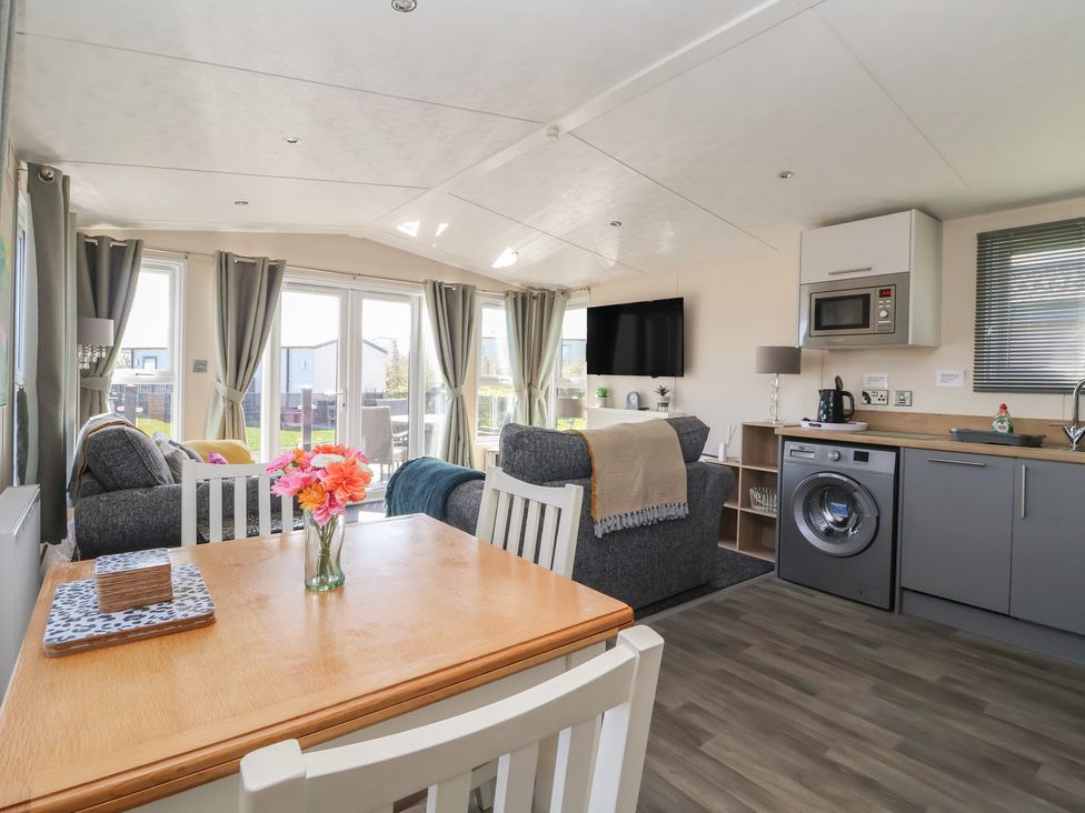 A living room with a dining area and kitchen appliances at Away Daze in Carnaby near Bridlington
