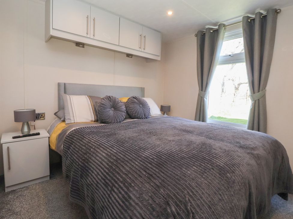 A bedroom with a bed and a bedside table at Away Daze in Carnaby near Bridlington