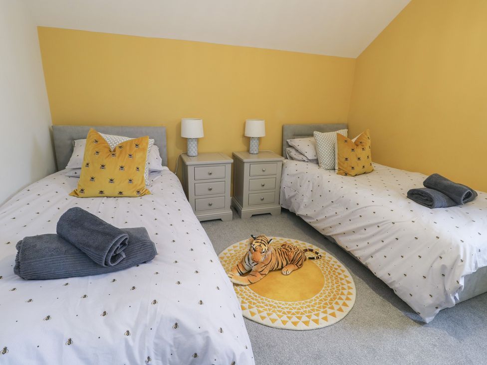 A bedroom with two beds and a tiger rug at 11 Parc Delfryn in Brynteg near Benllech