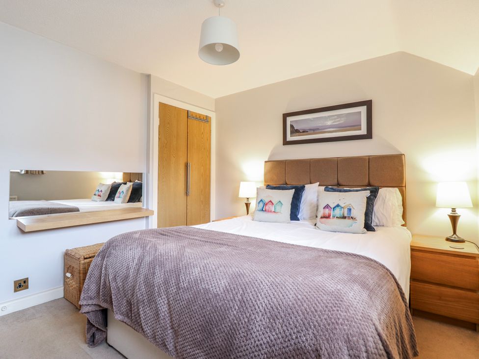 A bedroom with a bed and wardrobe at Green Cottage Borth-Y-Gest