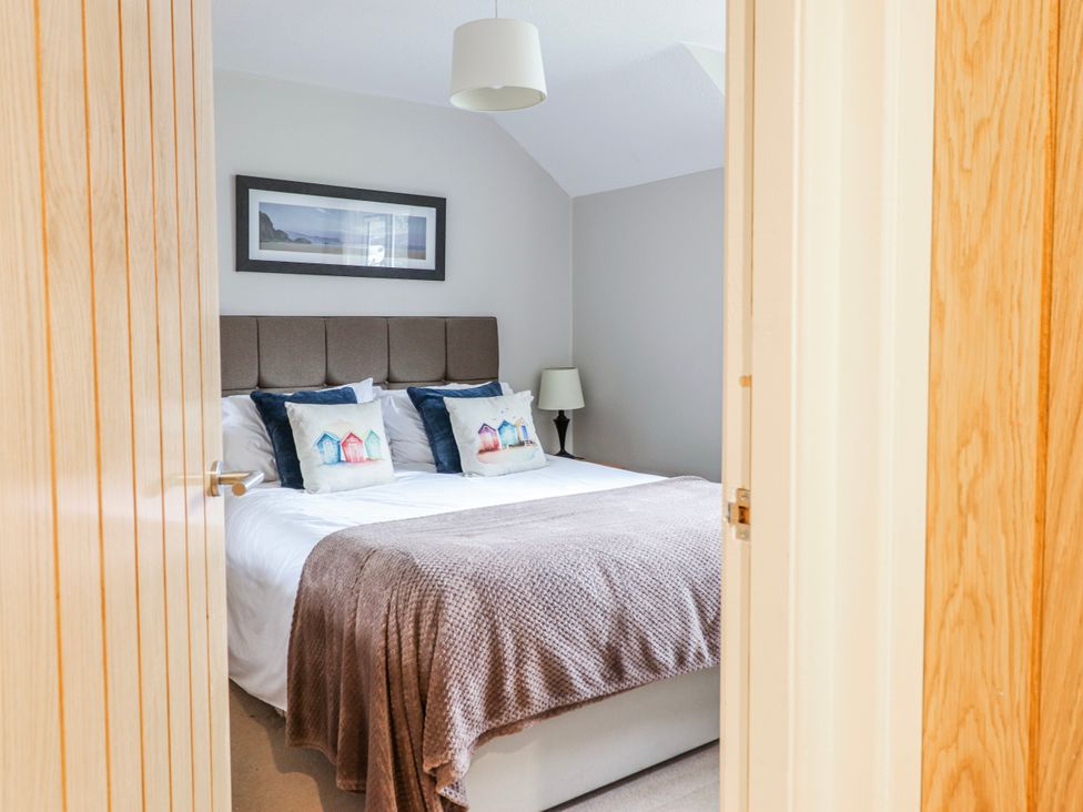 A bedroom with a bed and framed picture at Green Cottage in Borth-Y-Gest