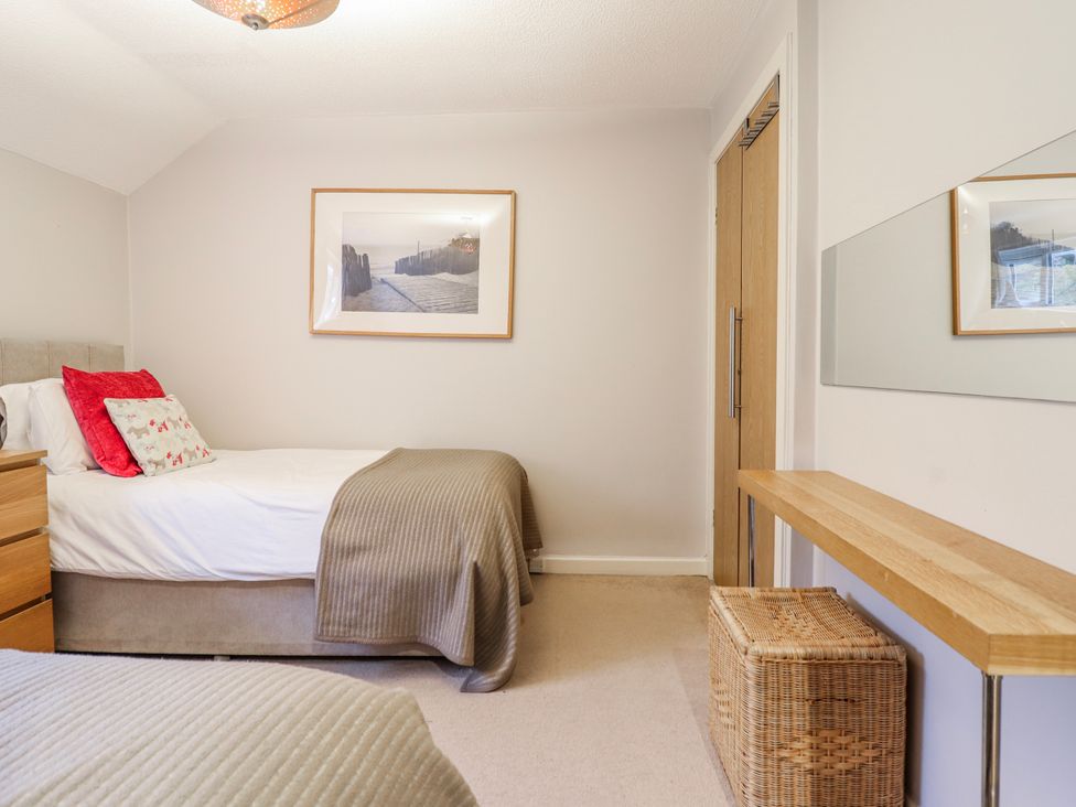 A bedroom with a bed and table at Green Cottage in Borth-Y-Gest
