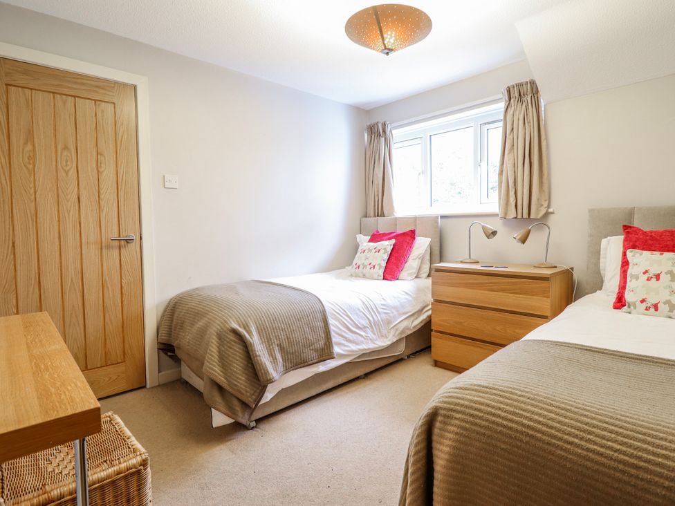 A bedroom with two single beds and a dresser at Green Cottage in Borth-Y-Gest