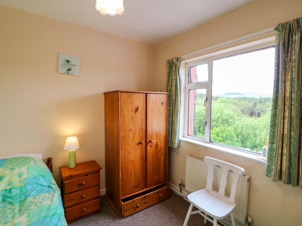 A bedroom with a bed and wardrobe at Forest View in Ballinskelligs, County Kerry