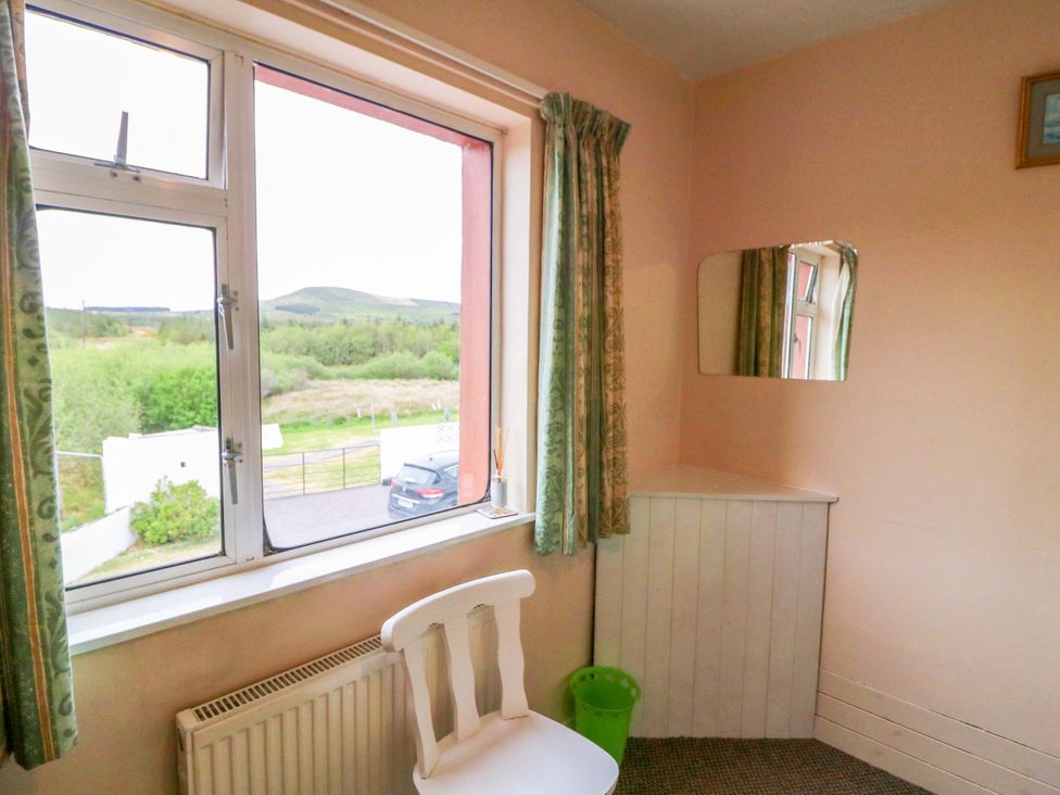 A bedroom with a window and chair at Forest View in Ballinskelligs, County Kerry