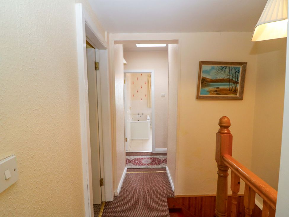 A hallway with a staircase and a bathroom entrance at Forest View, Ballinskelligs, County Kerry