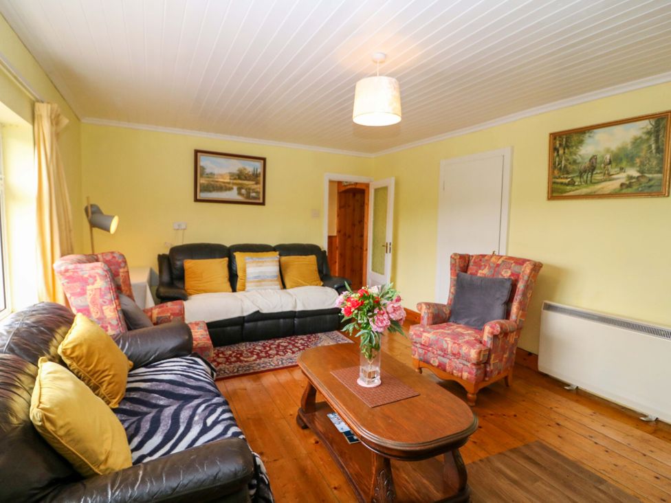A living room with a sofa, armchair, and coffee table at Forest View in Ballinskelligs, County Kerry
