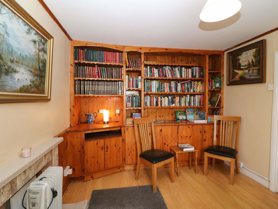 A snug with a bookshelf and table at Forest View in Ballinskelligs, County Kerry