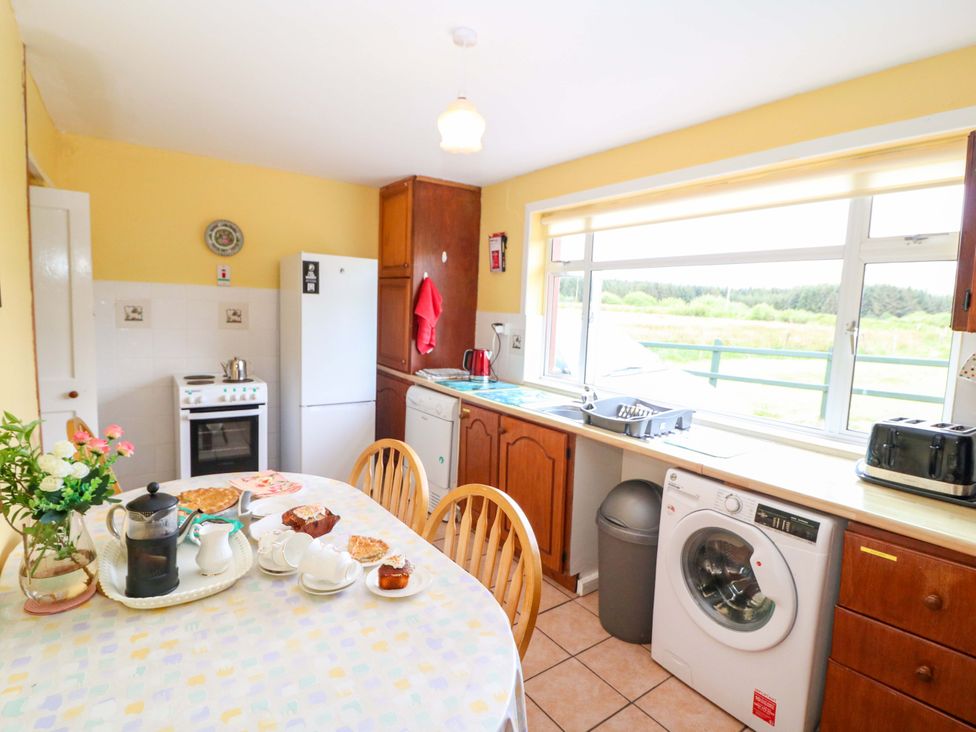 A kitchen with appliances and a dining table at Forest View in Ballinskelligs, County Kerry