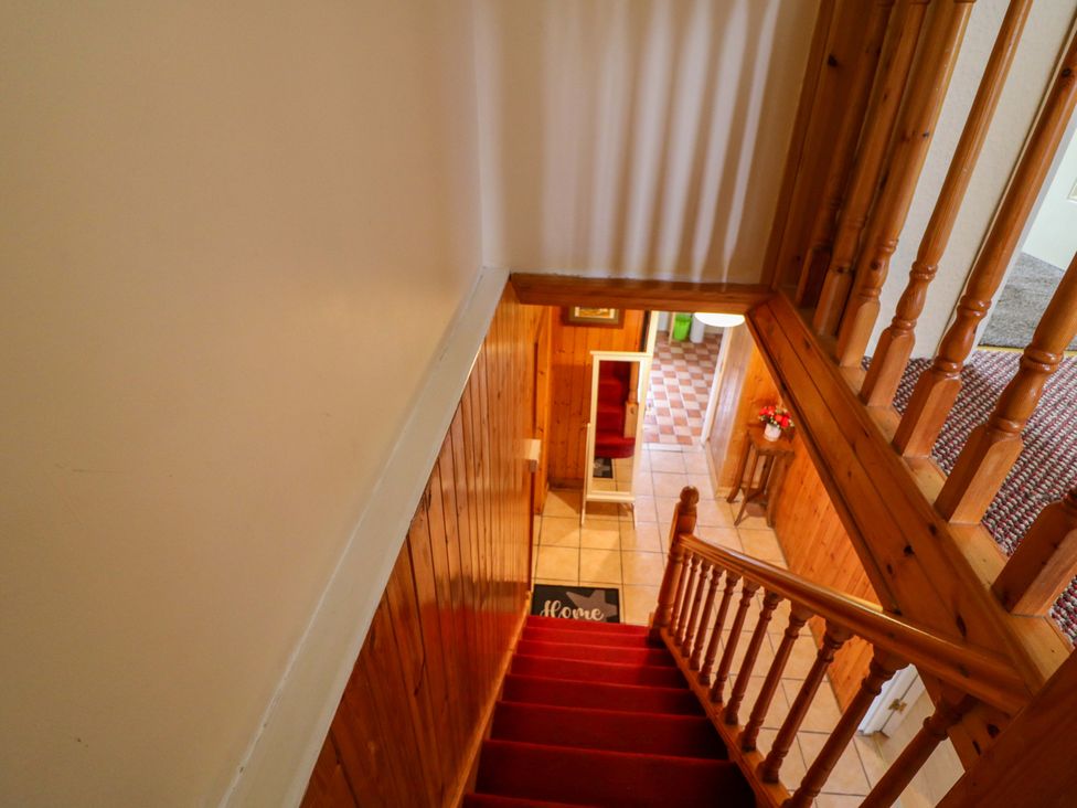 A staircase leading down to a hallway at Forest View in Ballinskelligs, County Kerry