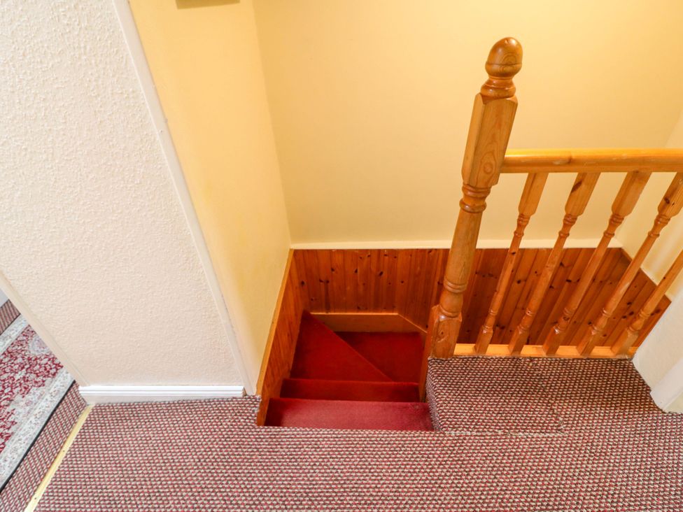 Stairs leading down with a wooden banister at Forest View in Ballinskelligs, County Kerry